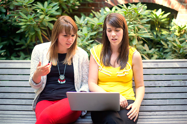 Two women discussing the redesign of their website.